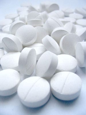 Pile of white prescription tablets with score lines, symbolizing Johnson & Johnson’s recalled medical products and patient safety concerns.