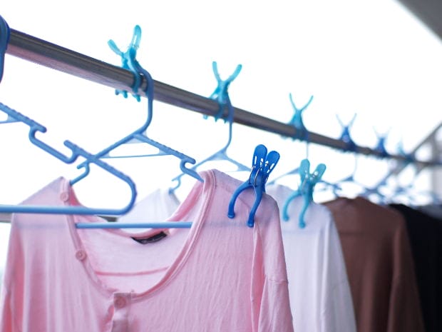 Secondary Asbestos Exposure – Clothing Contamination - Ferraro Law Firm Pink shirt and other clothing hanging on a clothesline with blue plastic