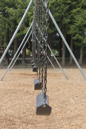 Empty Playground Swing Set – Asbestos Case Damages Example - Ferraro Law Firm Row of empty swings on a playground, symbolizing loss and damages in asbestos exposure cases like Soto v. Bargwarner Morse Tec Inc.