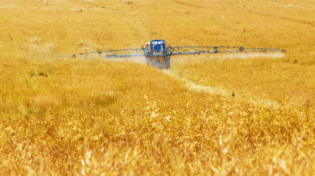 tractor spraying dangerous weed killer on crops that is subject of toxic tort case