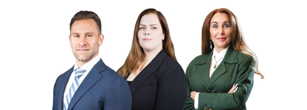 Three professionals posing in a row: man in blue suit, woman in black blazer, woman in green blazer, white background.